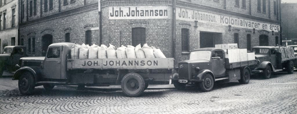 Historisk bildet av gammle lastebiler med mye varer på lasten